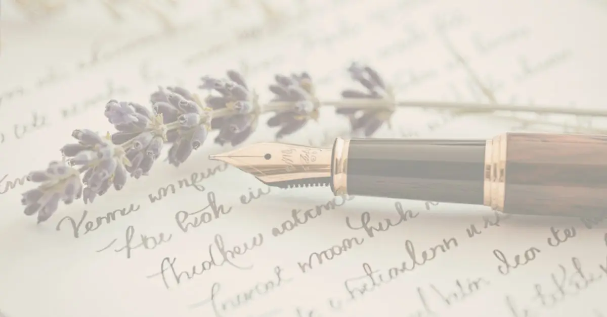 a flower, a pen and a page of poetry written in cursive