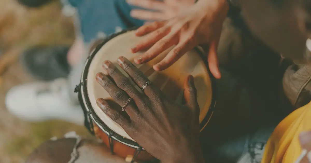 two female hands drumming on a bongo for beat poetry