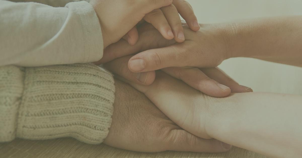 Hands stacked on top of one another, representing multiple generations