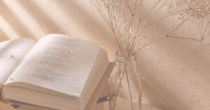 poetry book next to dried baby's breath in vase