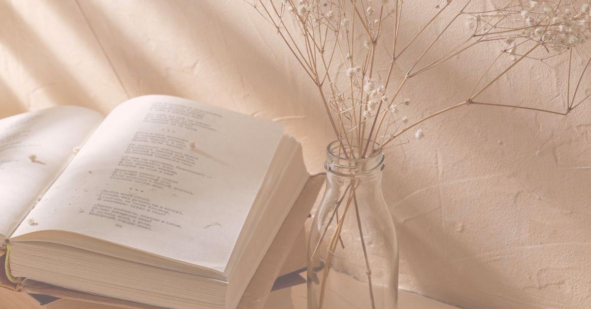 poetry book next to dried baby's breath in vase