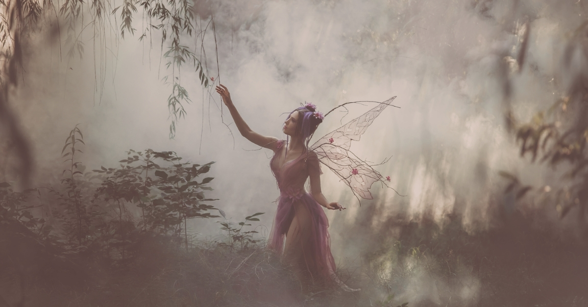 fairy touching plants in the woods in paranormal romance scene